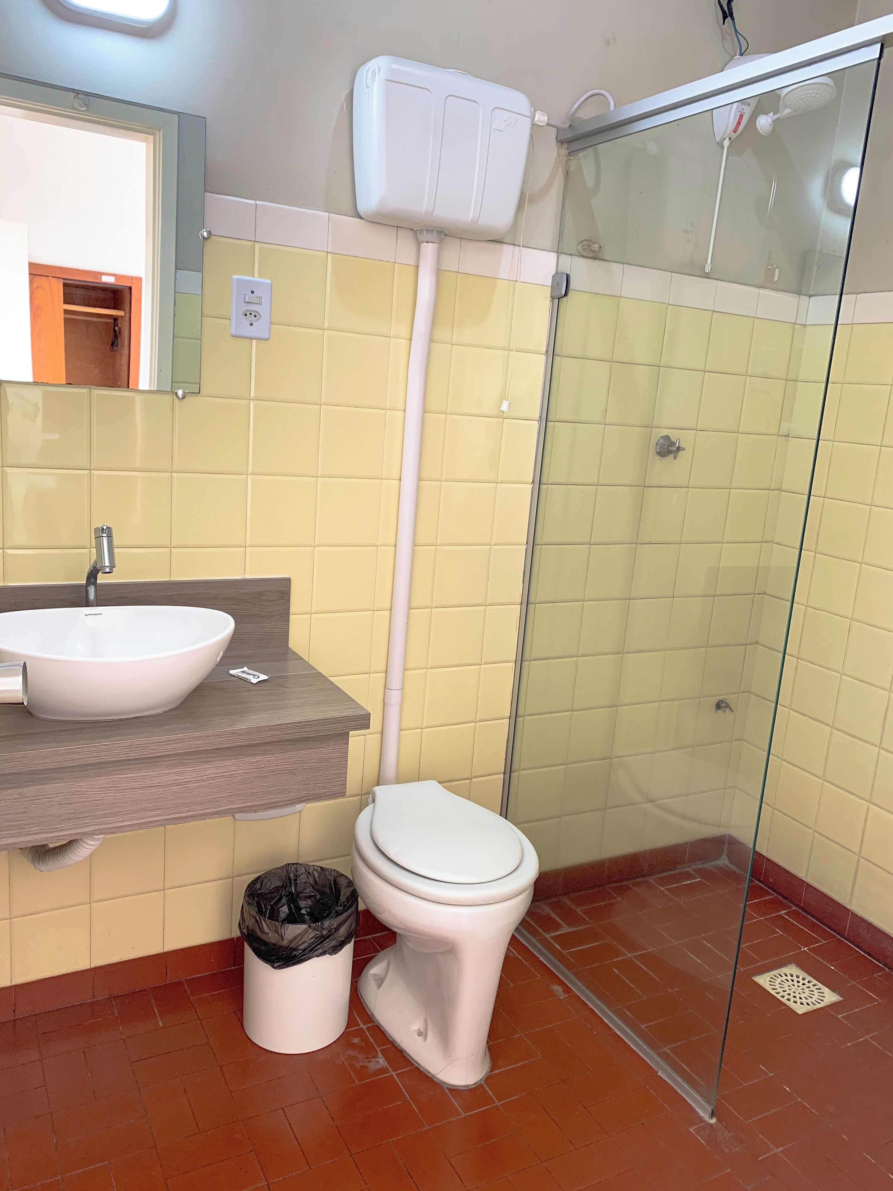 Un baño con un lavamanos blanco, un inodoro y una ducha con mampara de vidrio.