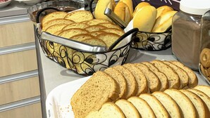 Een ontbijtbuffet met brood, gebak en drankjes.