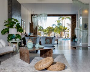 A modern living room with a sofa, coffee table, and woven baskets. - H2otel Boutique BY LD Hoteles (Paraguachí)