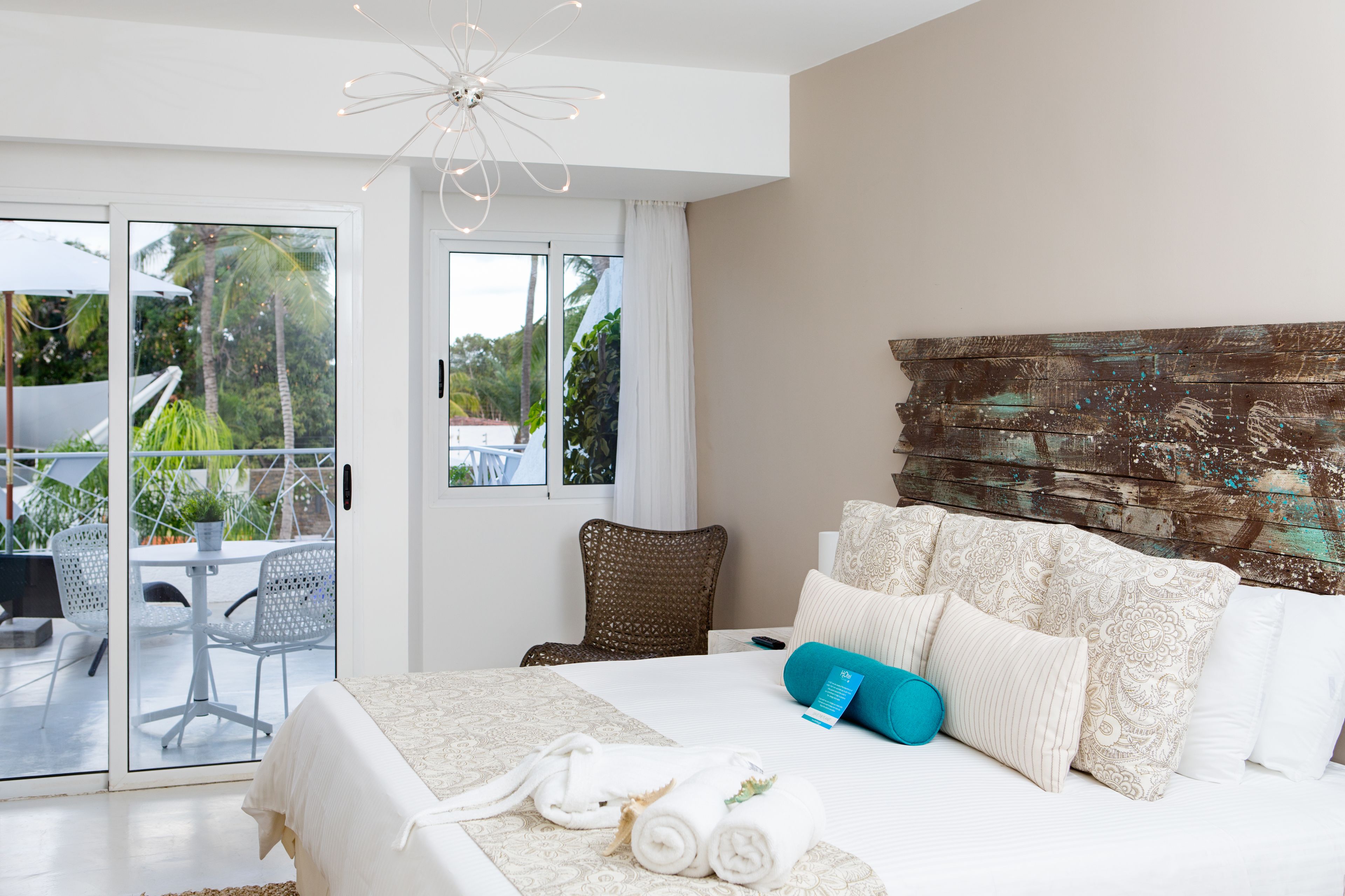 A hotel room with a bed, a view of the outdoors, a dining area, and a staircase.