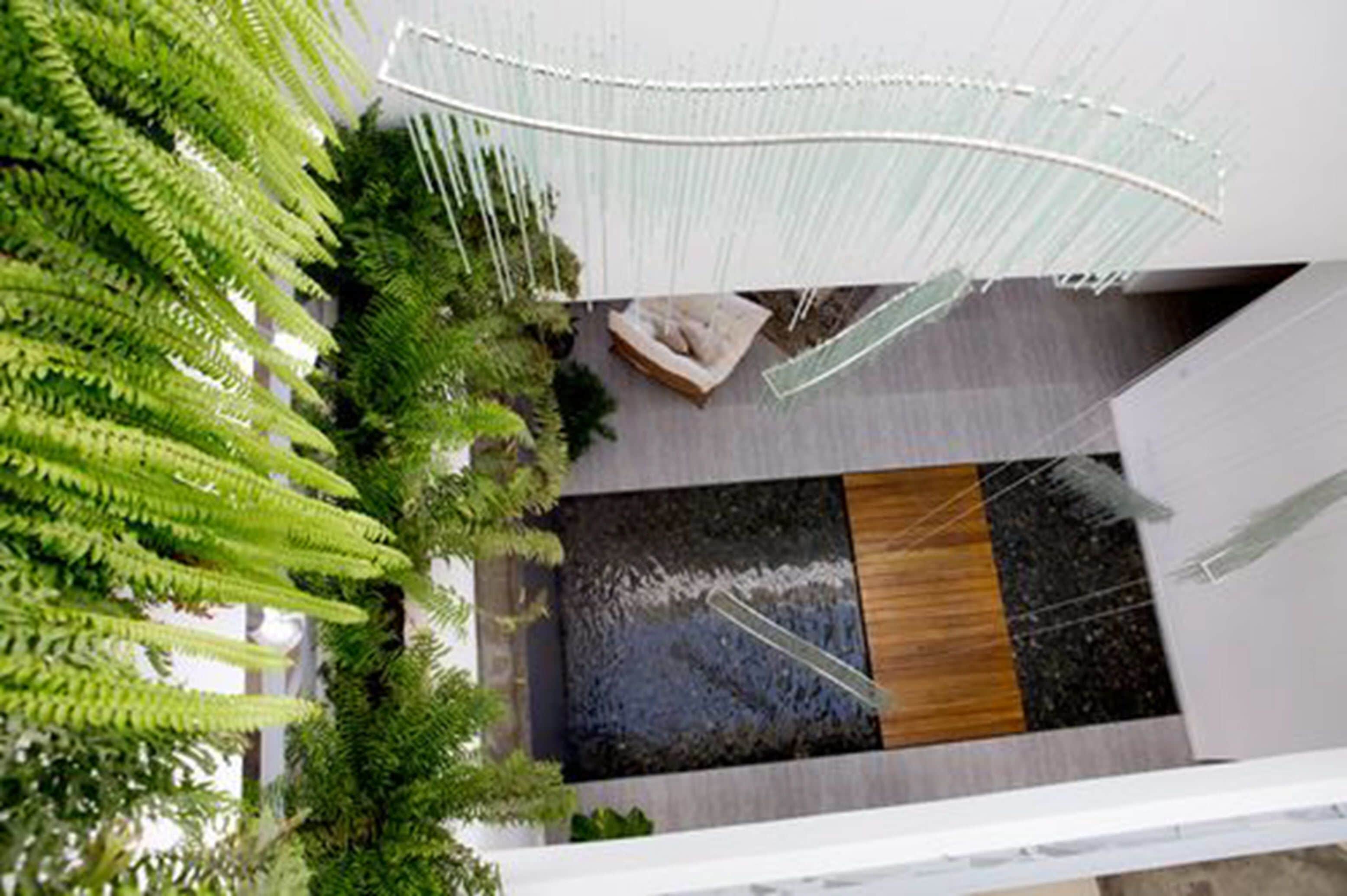 Een modern interieur met een waterpartij, zithoek en kamerplanten.