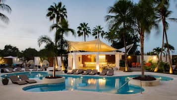 Una piscina al aire libre, sombrillas, tumbonas