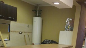 A reception area with a brick counter, a water heater, and a cabinet. - Casa Gobernador Gregores Patagonia (Gobernador Gregores)