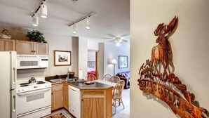 A modern kitchen with white appliances, wooden cabinets, and a central island. - River Run Village 2 Bedroom Condo - 100 yards to slopes, Pool, Hot Tub Access (Keystone)