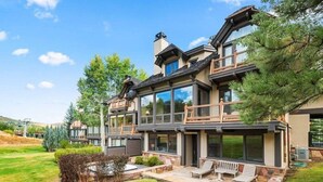 A modern two-story house with large windows, a balcony, and a well-maintained lawn. - Snowmass Owl Creek 9904 (Snowmass Village)