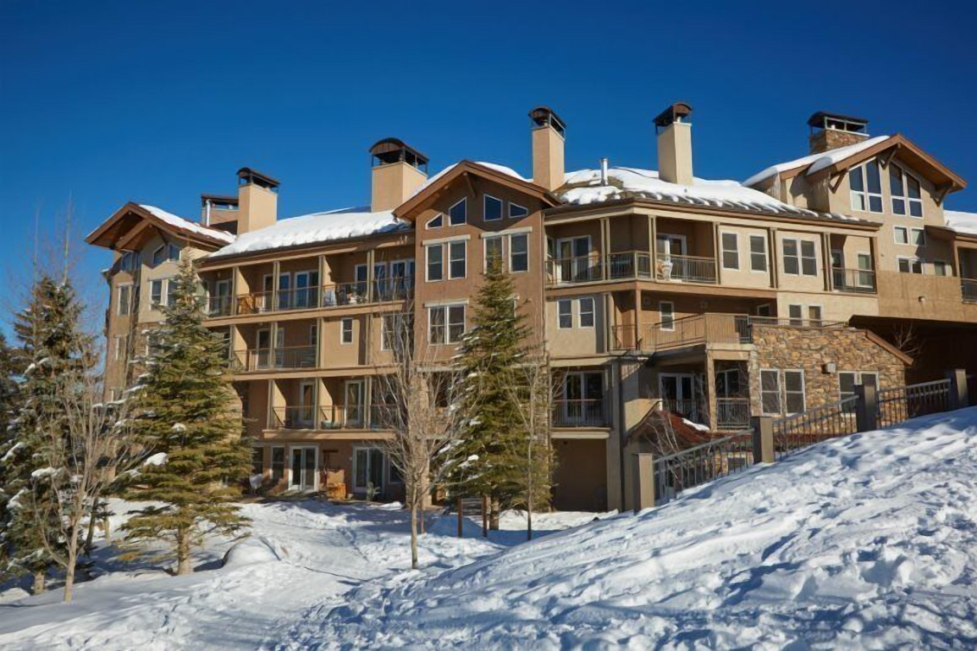 Un hotel de varios pisos con tejado cubierto de nieve y varias chimeneas.
