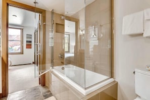 A modern bathroom with a glass-enclosed shower, a bathtub, and a toilet. - Ski in, Ski out, 2 Bedroom Luxury Residence with hot tub access and expansive views (Snowmass Village)