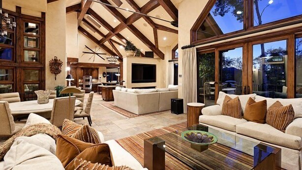 A spacious living area with a high ceiling, built-in wooden beams, a large TV, and comfortable seating. - Snowmass Castle Hill (Snowmass Village)