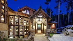 A large, multi-story building with a prominent entrance and a stone facade. - Snowmass Castle Hill (Snowmass Village)