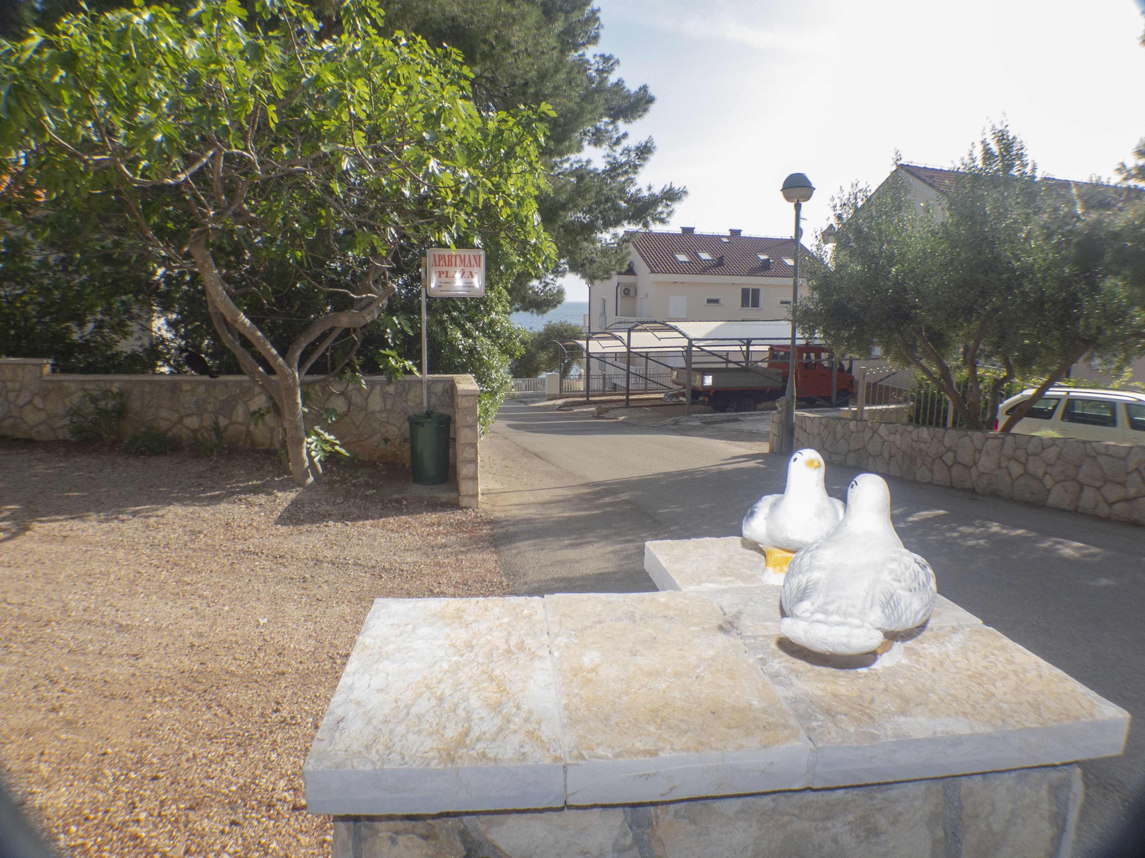 Una panchina in pietra con una scultura di uccello bianco al centro.