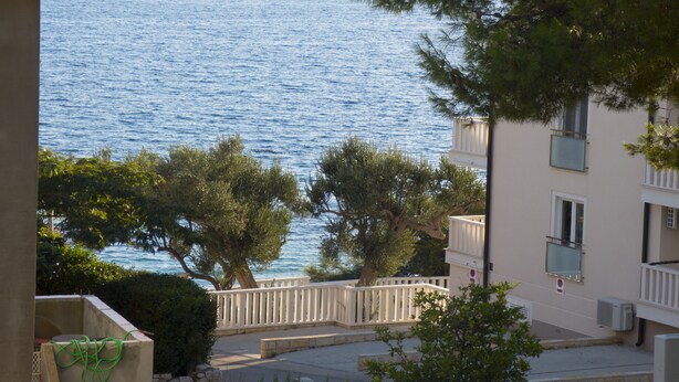 A coastal building with a view of the sea, a balcony, and a white fence. - Apartments Plaza (Jelsa)