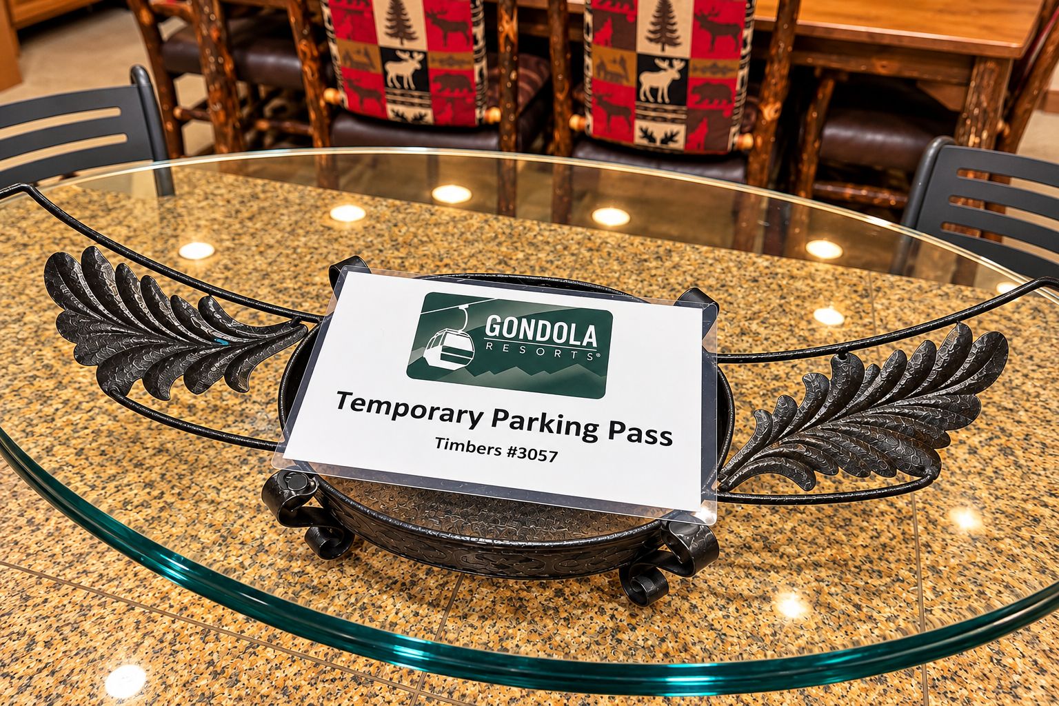 Una mesa de vidrio con un portaletapas para estacionamiento temporal que muestra la marca 'Gondola Resorts' y el texto 'Timbers #3057'.