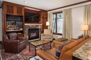 A living room with a fireplace, leather furniture, and a television. - Aspen Ritz Carlton 2 Bedroom Residence (Aspen)