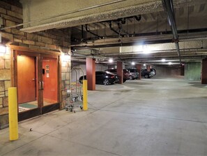 Un aparcamiento subterráneo de varios niveles con varios coches estacionados.