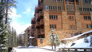 A multi-story hotel with stone and wood exterior, balconies, and a snowy environment. - 30577 The Timbers (Keystone)