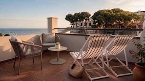 A terrace with two wicker chairs, a small round table, and a potted plant. - Hotel Medium Montecarlo  (Llafranc)