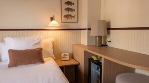 A hotel room with a bed, bedside table, lamp, and a wall-mounted picture of fish. - Hotel Medium Montecarlo  (Llafranc)