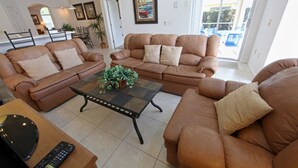 A spacious living room with two brown leather sofas, a coffee table, and a TV stand. - 3BR 2BA Home in Rolling Hiils by CV-2616 (Kissimmee)