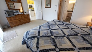 A bedroom with a large bed, a dresser, a television on the dresser, and a door leading to another room. - 3BR 2BA Home in Rolling Hiils by CV-2616 (Kissimmee)