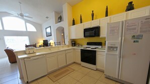 A kitchen with white cabinets, a microwave, a stove, and a refrigerator. - 3BR 2BA Home in Rolling Hiils by CV-2616 (Kissimmee)