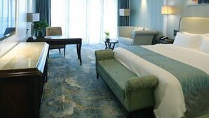 Une chambre d’hôtel avec un lit, un bureau, une chaise et un canapé.