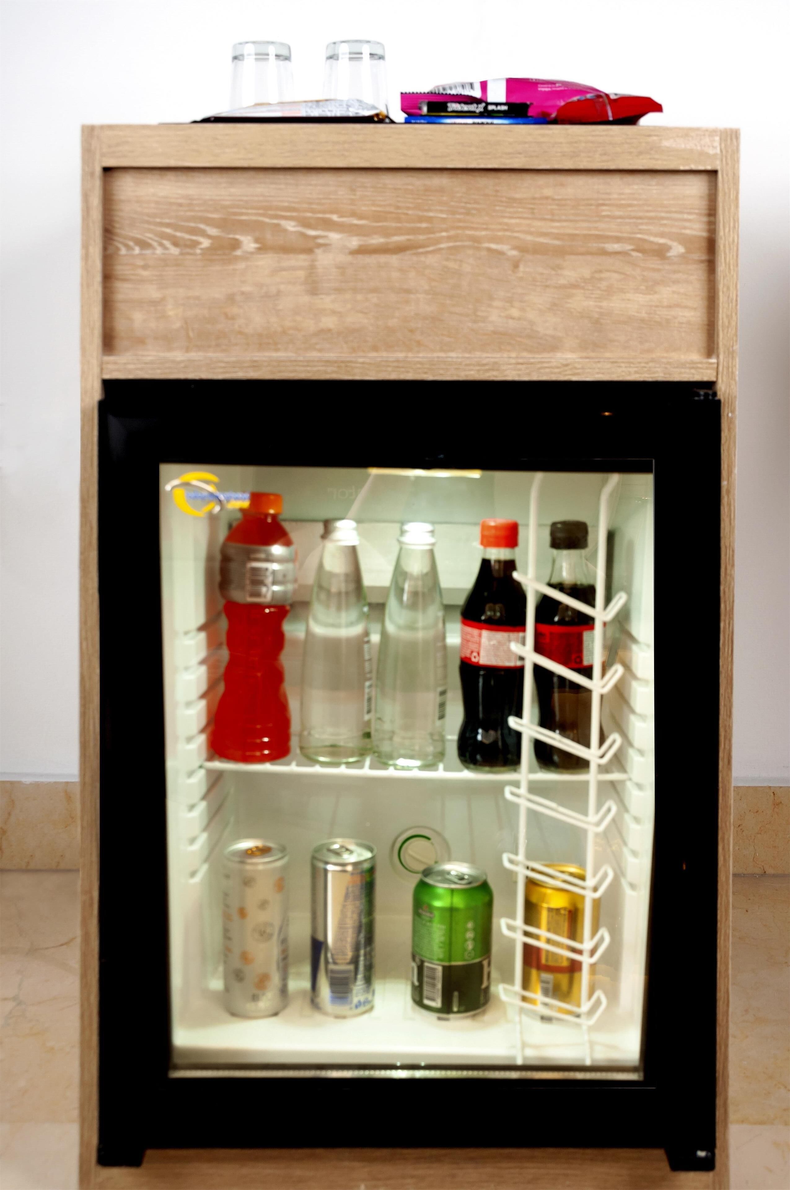 A mini-fridge with bottles and cans.