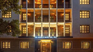 Un hotel de varios pisos con balcones, una entrada central y un cartel que dice "Boulevard del Rio".