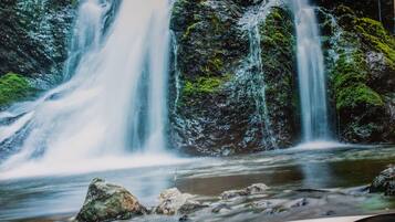 Una cascada con una bañera blanca al frente.
