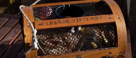 A wooden chest with the inscription "CABANA FISTEAR" on a wooden table outdoors.