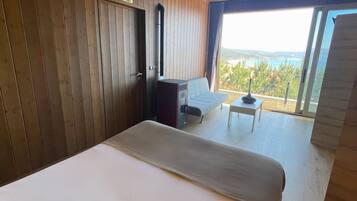 Une chambre avec un grand lit, un bureau et une vue sur l’extérieur.