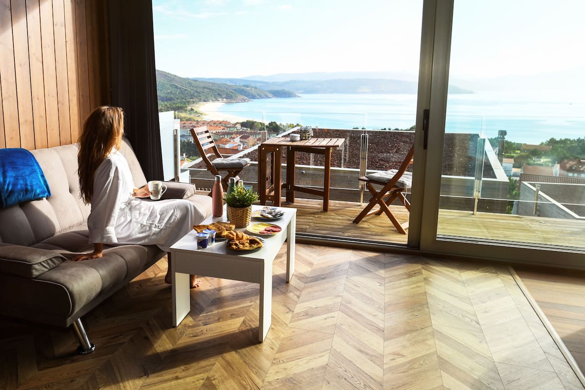 A modern living room with a large window overlooking a scenic coastal view.