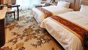 A hotel room with two beds, a desk with a lamp, and a large window with curtains. - Jinxi International Hotel (Fuzhou)