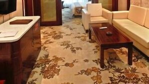 A modern living room with a sofa, a coffee table, and a TV. - Jinxi International Hotel (Fuzhou)