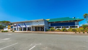 A Surf Club building with a green roof and a signboard.