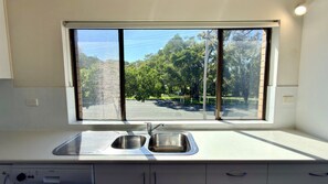 A kitchen with a window, a sink, and cabinets.