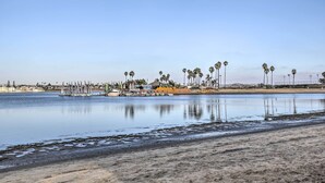 Ein Strand mit ruhiger See, Palmen und einer Reihe von Booten.