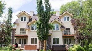 A two-story house with a covered patio, a hot tub, and a well-maintained garden. - Beautiful Driggs Townhome with Views and Hot Tub (Driggs)