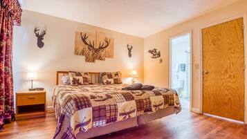 Une chambre avec un grand lit, deux lampes de chevet et des décorations murales sur le thème des cerfs.