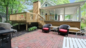 A covered outdoor patio with wicker chairs and a grill. - B and B's Beach House Accommodates Eleven Guests In 5 Bedrooms 2 Full Baths! (South Haven)