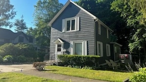 A two-story house with a gabled roof, white trim, and a small front porch. - B and B's Beach House Accommodates Eleven Guests In 5 Bedrooms 2 Full Baths! (South Haven)