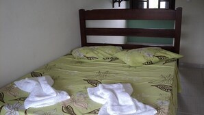 Een bed met bloemenbeddengoed en twee handdoeken erop.