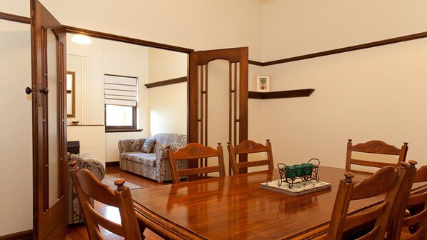 A dining room with a wooden table, six chairs, and a decorative tray. - An inviting centrally located retreat (Warrnambool)