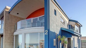 Un edificio moderno su due piani con un balcone curvo, ampie finestre e il numero '2' ben visibile sulla facciata.