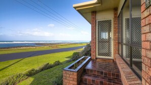 A residential property with a view of the ocean, a paved driveway, and a brick exterior. - Perfect for that cosy winter holiday with stunning views of the Pea Soup Cove. (PORT FAIRY)