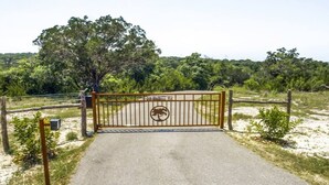 Une entrée fermée par un portail en métal et agrémentée d’un panneau arborant un symbole d’arbre.