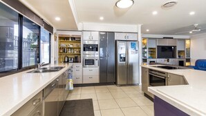 A modern kitchen with stainless steel appliances, a built-in oven, and a large refrigerator.