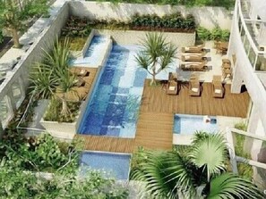 Una piscina al aire libre, sillones reclinables de piscina