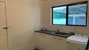A small kitchen with a window, a sink, and a toilet. - Lowset Pet Friendly Home (BONGAREE)