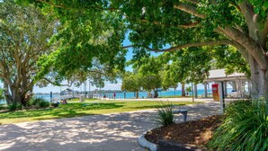 A park with a paved walkway, benches, and a gazebo overlooking a body of water. - Bribie Waters On Welsby (BONGAREE)