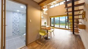 A modern interior with a dining area, a staircase, and a view of the outdoors. - Gyeongpoen Pension (Gangneung)